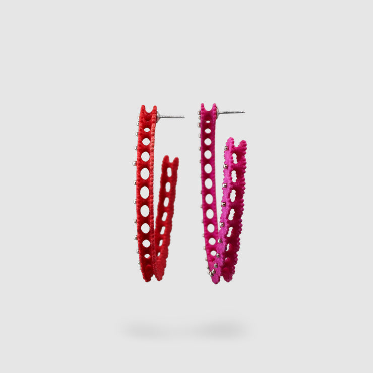 A true showstopper, these large wave hoops explore asymmetry through reflection - each earring a mirrored form of the other, one in bold red and the other in vibrant pink. Part of the PHAOS collection, they’re crafted from hand-dyed, 3D-printed bioplastic and paired with .925 silver. Their sculptural, undulating design offers a contemporary twist on the ancient art of granulation, blending heritage techniques with digital innovation. Finished with our signature post fastening for a secure, all-day comfortab