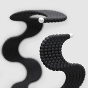 This lightweight cuff bracelet from the PHAOS collection is crafted from hand-dyed, 3D printed bioplastic and accented with glass pearls. Made from a renewable, plant-based polyamide derived from vegetable oil, each piece is hand-finished in your choice of colour; blending sustainable innovation with bold, contemporary design.