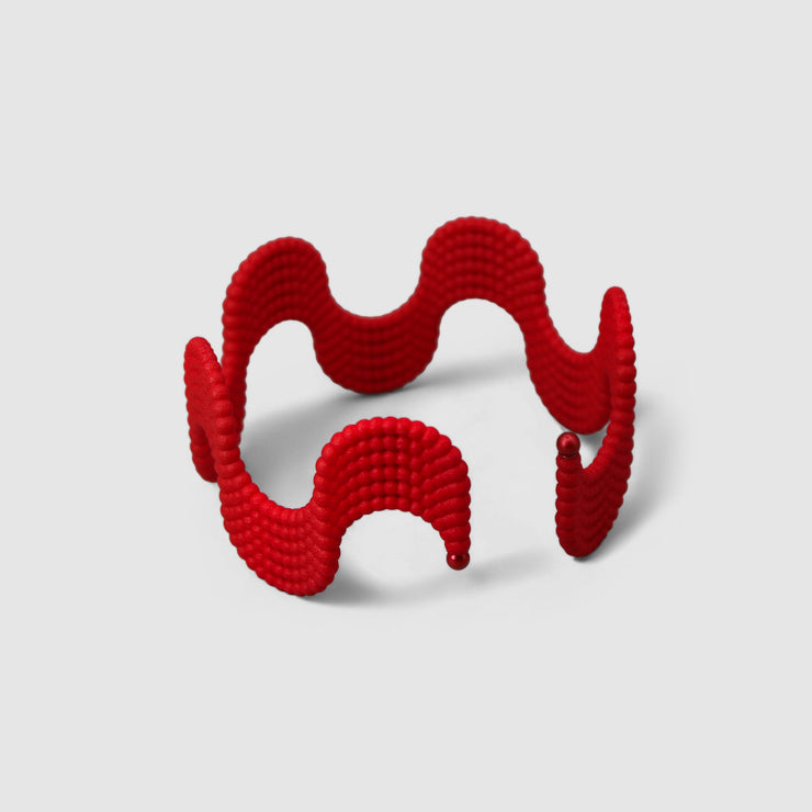This lightweight cuff bracelet from the PHAOS collection is crafted from hand-dyed, 3D printed bioplastic and accented with glass pearls. Made from a renewable, plant-based polyamide derived from vegetable oil, each piece is hand-finished in your choice of colour; blending sustainable innovation with bold, contemporary design.