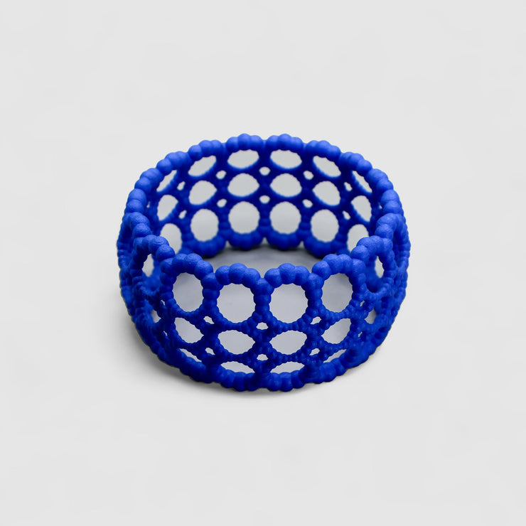 Playful bangle bracelet from 3D printed bioplastic of the PHAOS collection, hand-dyed in royal blue or a pink and red hue. This material is a polyamide powder made out of renewable resources that come from vegetable oil.