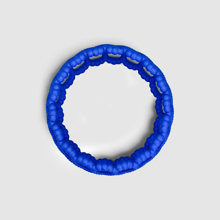 Playful bangle bracelet from 3D printed bioplastic of the PHAOS collection, hand-dyed in royal blue or a pink and red hue. This material is a polyamide powder made out of renewable resources that come from vegetable oil.