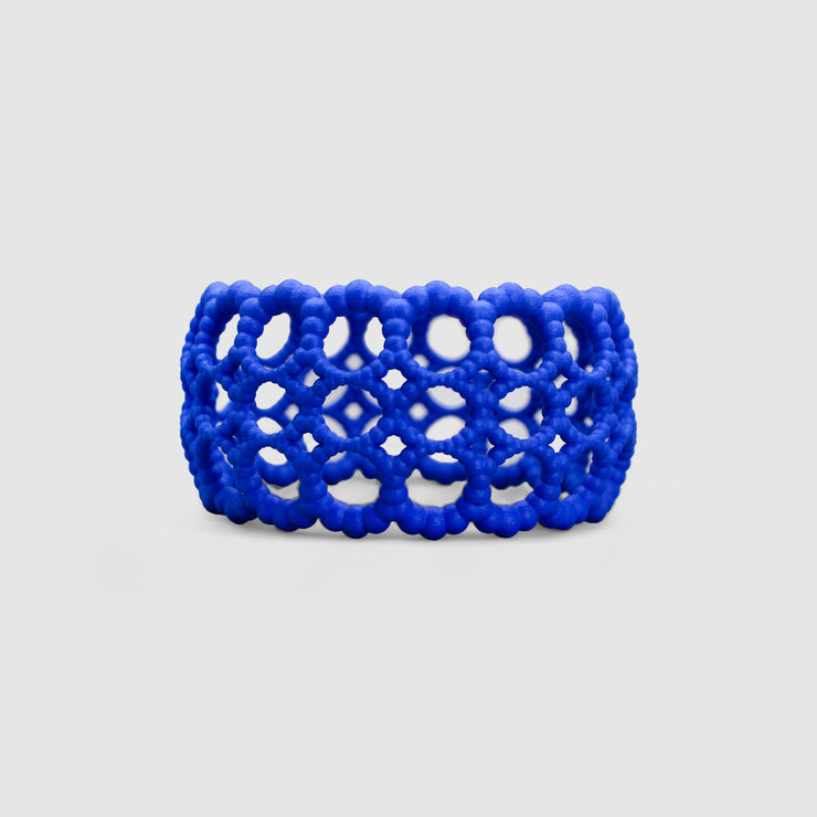 Playful bangle bracelet from 3D printed bioplastic of the PHAOS collection, hand-dyed in royal blue or a pink and red hue. This material is a polyamide powder made out of renewable resources that come from vegetable oil.