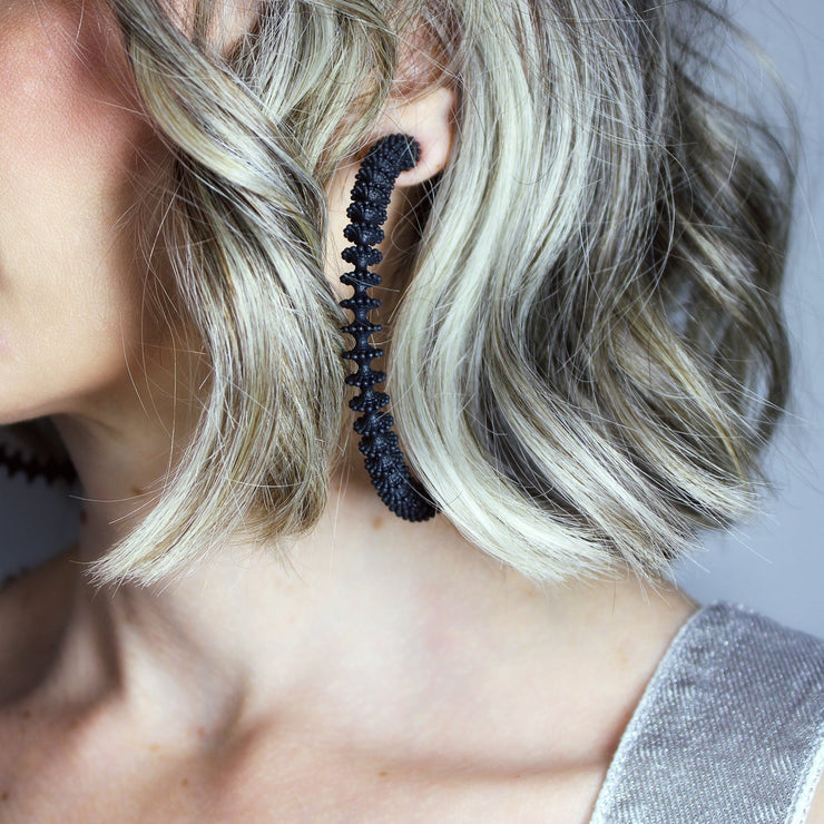 These bold, modern hoop earrings pay homage to the ancient technique of granulation - reimagined through a futuristic lens. Crafted from 3D-printed bioplastic, they’re finished with our signature .925 silver post fastening for all-day comfort on pierced ears.