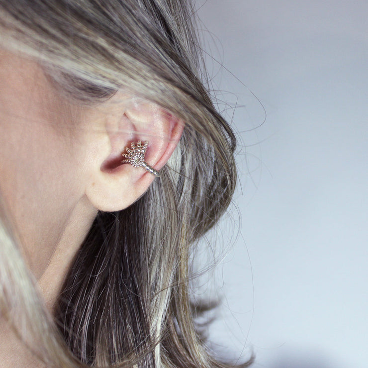 This finely detailed ear cuff from the PHAOS collection offers an innovative reinterpretation of the ancient granulation technique, brought to life through digital design and modern craftsmanship. Its sculptural form wraps elegantly around the ear without the need for a piercing, creating a bold yet refined statement. Available in your choice of gold-plated brass or .925 silver, it’s a contemporary piece that merges heritage with high-tech precision.