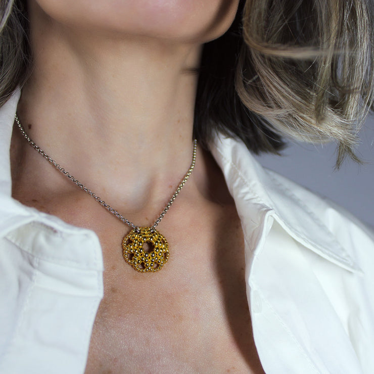 An artfully detailed pendant with a striking geometric form, crafted from gold-plated brass and paired with a .925 silver chain from the PHAOS collection. Make a subtle statement by layering it along with other pieces. Bold yet delicate, this pendant necklace makes the perfect gift.