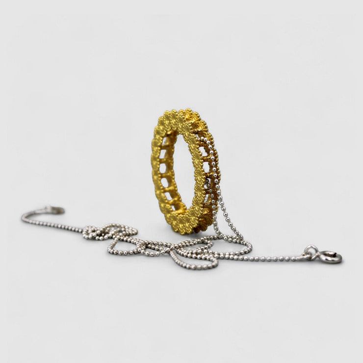 Striking yet refined, this pendant features an artfully detailed, geometric design crafted from gold-plated brass and suspended from a .925 silver chain - part of the PHAOS collection. Whether worn alone or layered with other pieces, it adds a subtle edge to any look. 