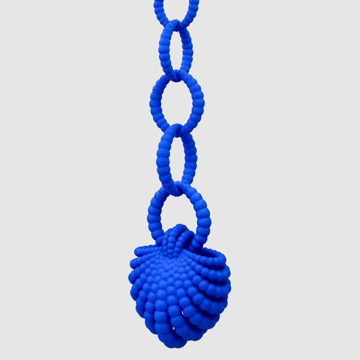 With its fluid Y silhouette and finely interlocking details, this pendant is crafted from bioplastic and suspended from a .925 silver chain. Hand-dyed in royal blue or peacock teal, it’s a subtly seductive piece that reinterprets the ancient art of granulation through a modern lens.