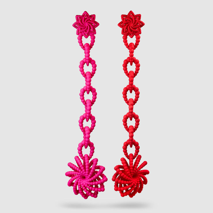 Crafted from ultra-light, 3D-printed bioplastic, these head-turning earrings are a true statement piece. Part of the captivating PHAOS collection, they feature a hand-dyed finish - one in bold red, the other in vibrant pink - bringing a playful contrast to any look. Finished with our signature post fastening for all-day comfort on pierced ears.