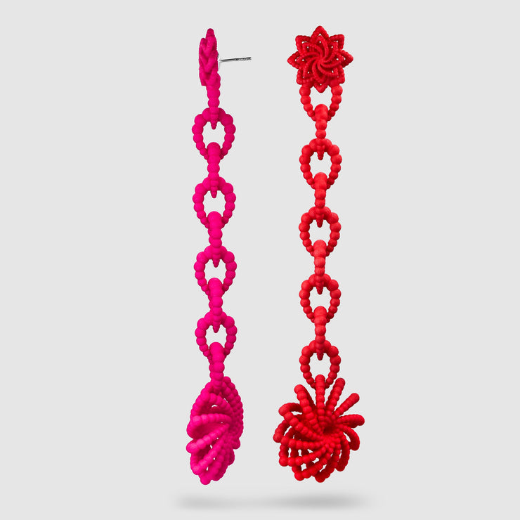 Crafted from ultra-light, 3D-printed bioplastic, these head-turning earrings are a true statement piece. Part of the captivating PHAOS collection, they feature a hand-dyed finish - one in bold red, the other in vibrant pink - bringing a playful contrast to any look. Finished with our signature post fastening for all-day comfort on pierced ears.
