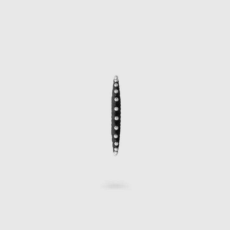 This sophisticated ear cuff from the PHAOS collection reimagines the ancient granulation technique through digital design and contemporary craftsmanship. Designed to sit securely without a piercing, its geometric shape curves around the ear. Hand-dyed and finished with care, each piece features a subtle touch of .925 silver.