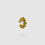 This sophisticated ear cuff from the PHAOS collection reimagines the ancient granulation technique through digital design and contemporary craftsmanship. Designed to sit securely without a piercing, its geometric shape curves around the ear. Available in your choice of gold-plated brass or .925 silver.