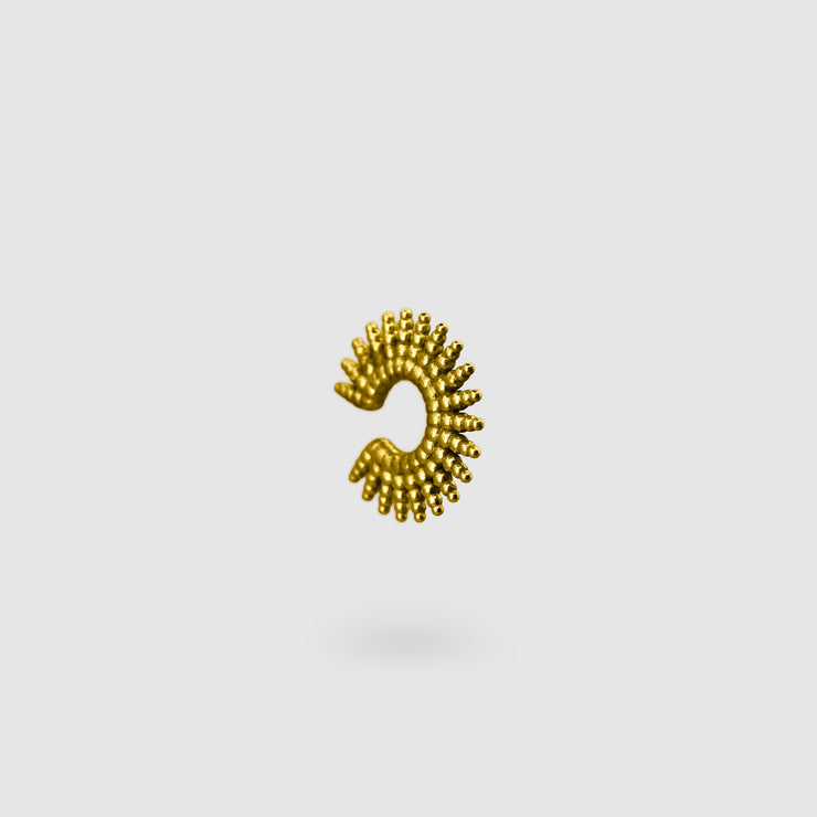 This sophisticated ear cuff from the PHAOS collection reimagines the ancient granulation technique through digital design and contemporary craftsmanship. Designed to sit securely without a piercing, its geometric shape curves around the ear. Available in your choice of gold-plated brass or .925 silver.