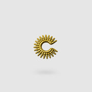 This sophisticated ear cuff from the PHAOS collection reimagines the ancient granulation technique through digital design and contemporary craftsmanship. Designed to sit securely without a piercing, its geometric shape curves around the ear. Available in your choice of gold-plated brass or .925 silver.
