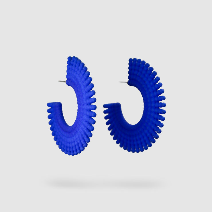 Crafted from ultra-light 3D printed bioplastic, these sculptural earrings bring a touch of playful sophistication to any look. Part of the enchanting PHAOS collection, each pair is hand-dyed in a vibrant palette, creating a sense of movement and intrigue. Secured with our signature .925 silver post fastening for lasting comfort on pierced ears.