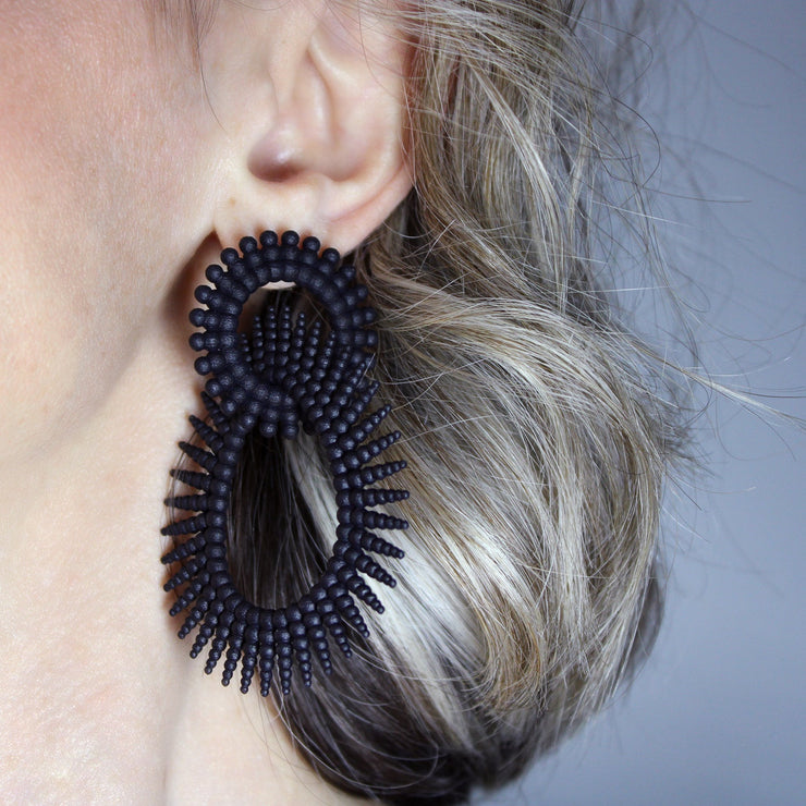 Crafted from ultra-light 3D printed bioplastic, these stunning earrings are true statement pieces. Part of the captivating PHAOS collection, their hand-dyed finish in a unique variety of vibrant colours, adds a touch of mystery and elegance to any look. Featuring our signature post fastening for all-day comfort on pierced ears.